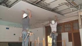 Picture of a drywall crew hanging drywall on the ceiling in a New York City Apartment building.