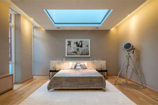 Master bedroom picture of a New York City apartment. Tan walls and white ceiling paint.